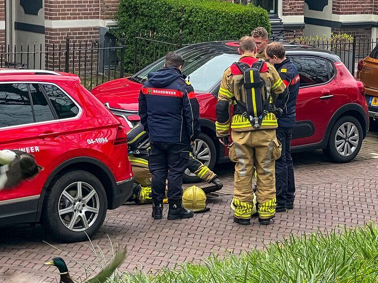 Brandweerlieden zijn op zoek naar de herkomst van de benzinelucht. - Foto: Martijn Schaap